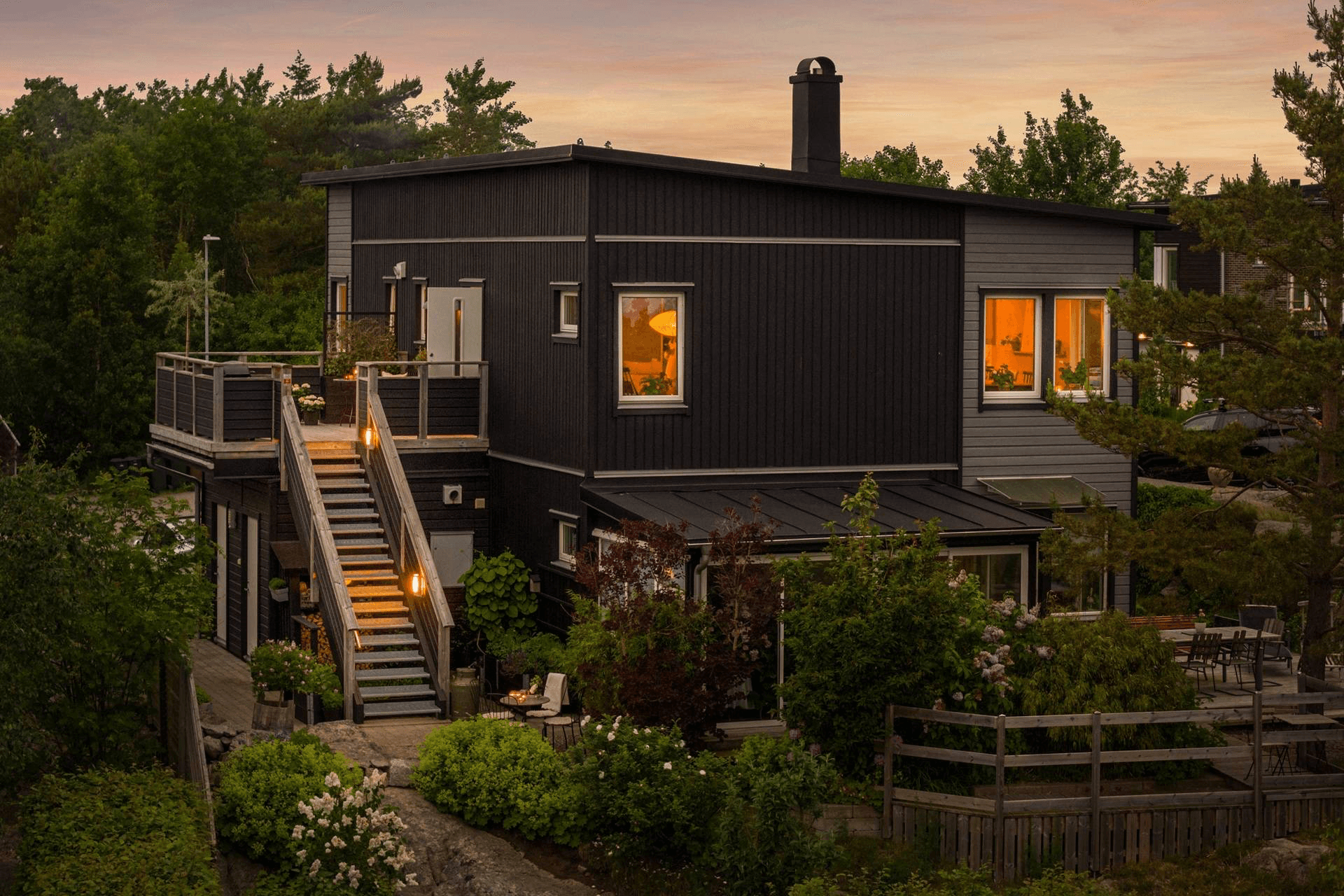 En villa i vinterskymning med ljus i fönstren