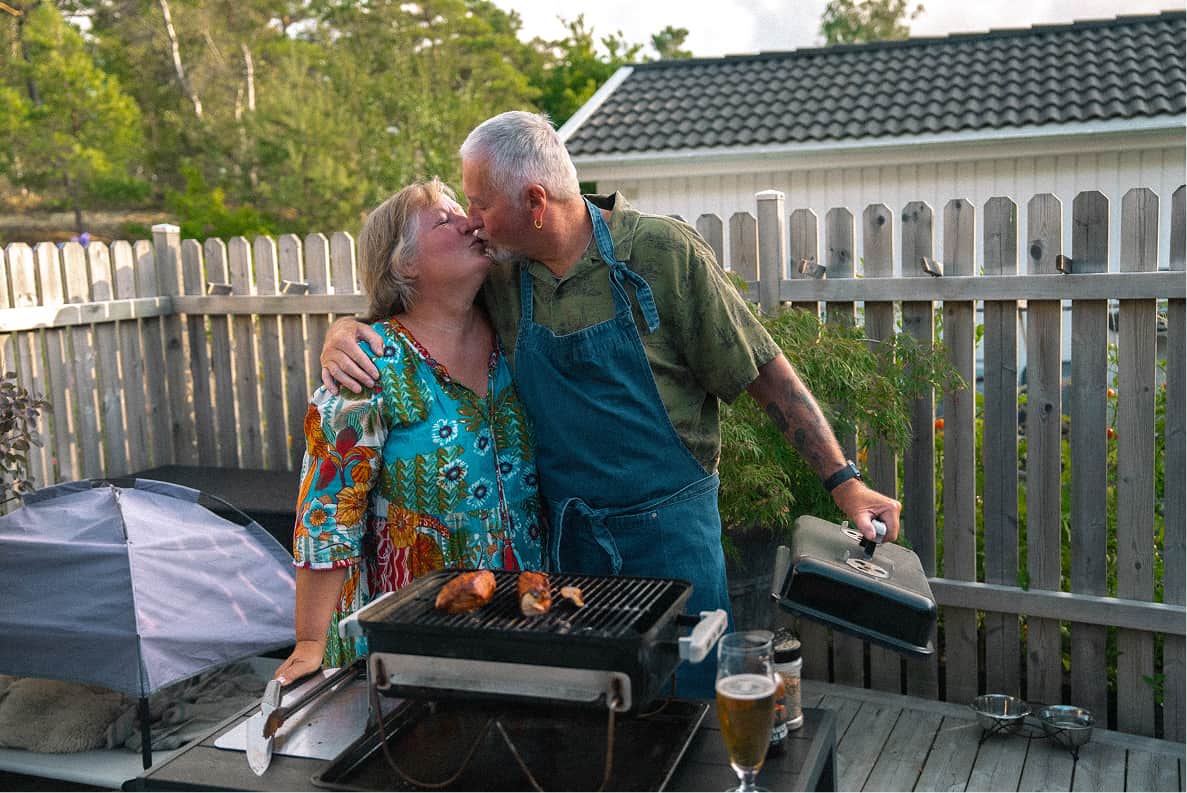 Anneli and Thomas kissing by the barbecue on their deck