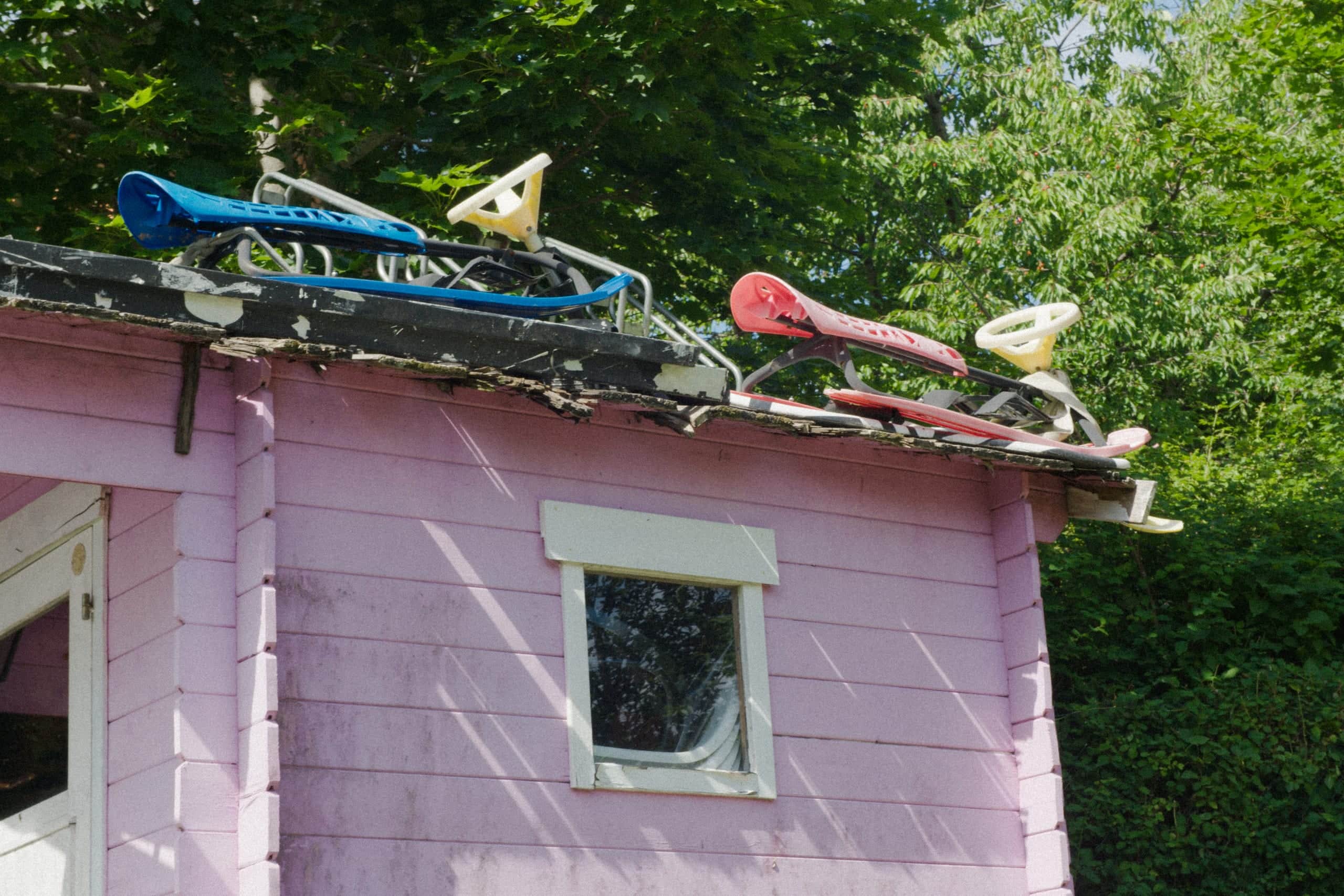 Two snow racers on the roof of a pink playhouse