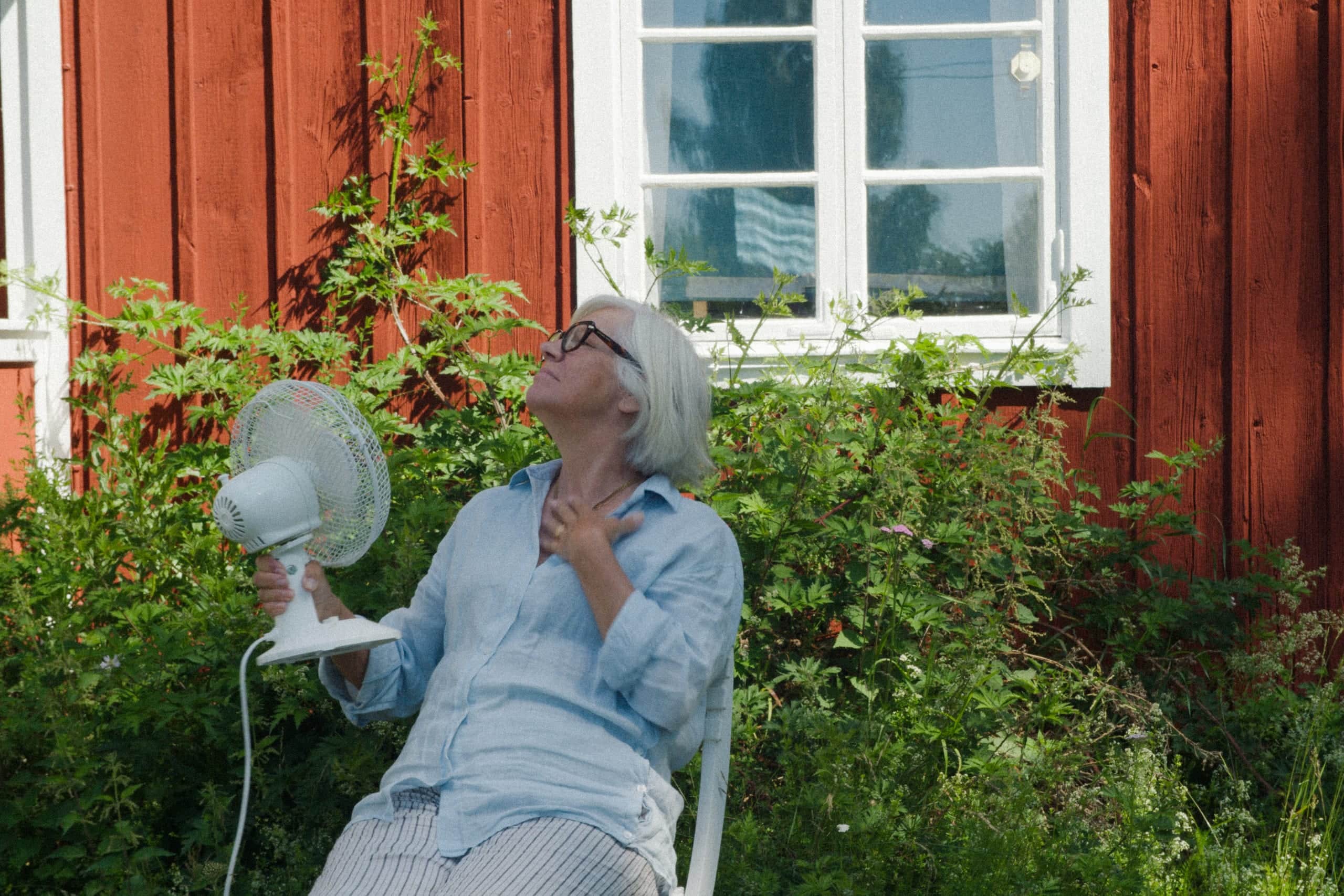 Elvy customer by a red country cottage garden