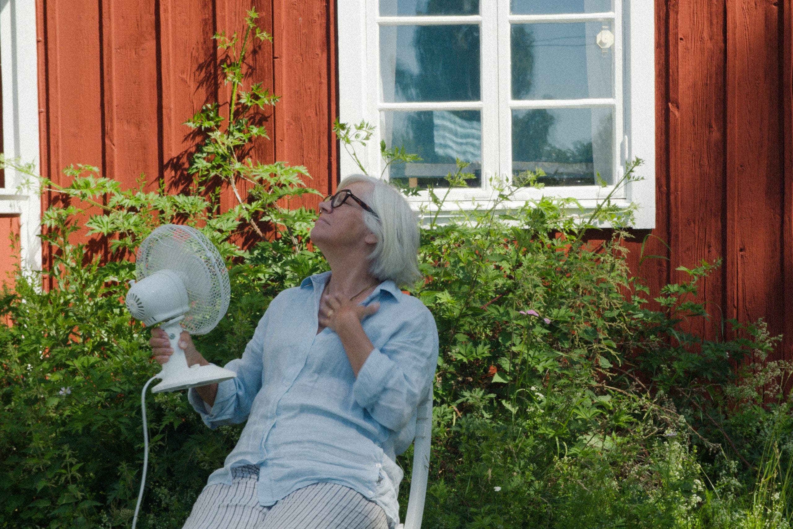 Elvy-kund vid trädgården till ett rött torp