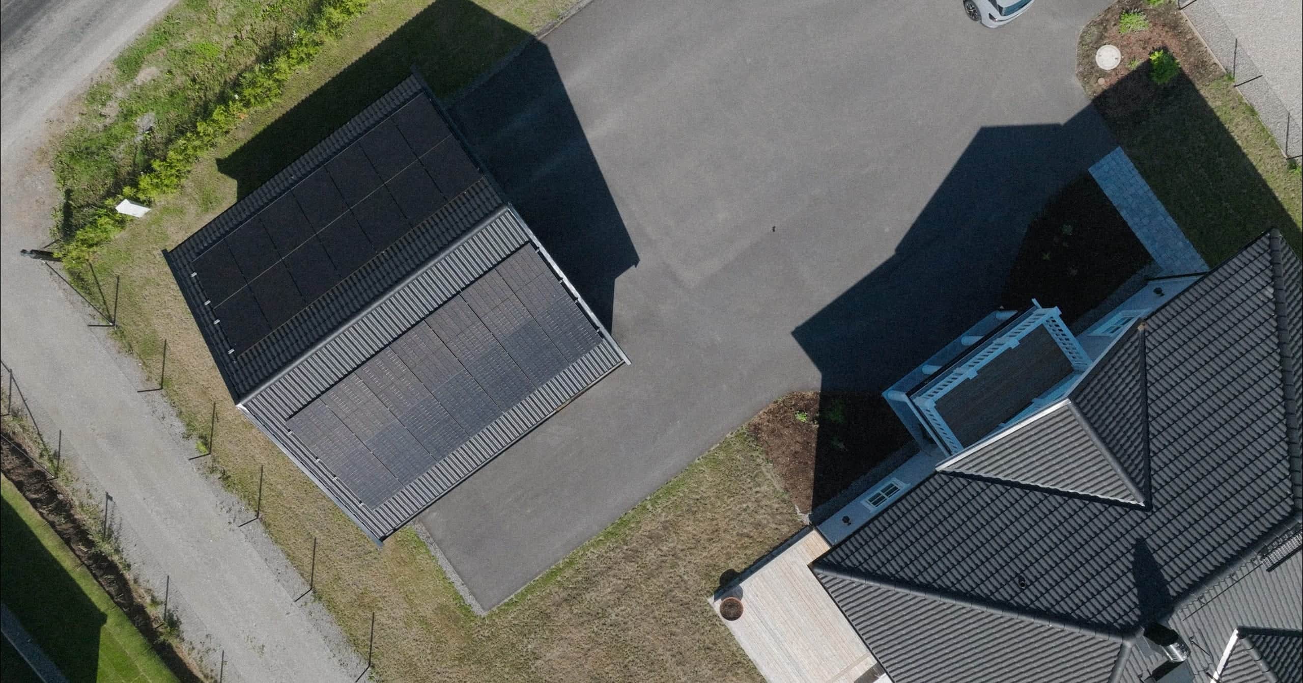 Aerial view of solar panels on a carport roof in a residential area