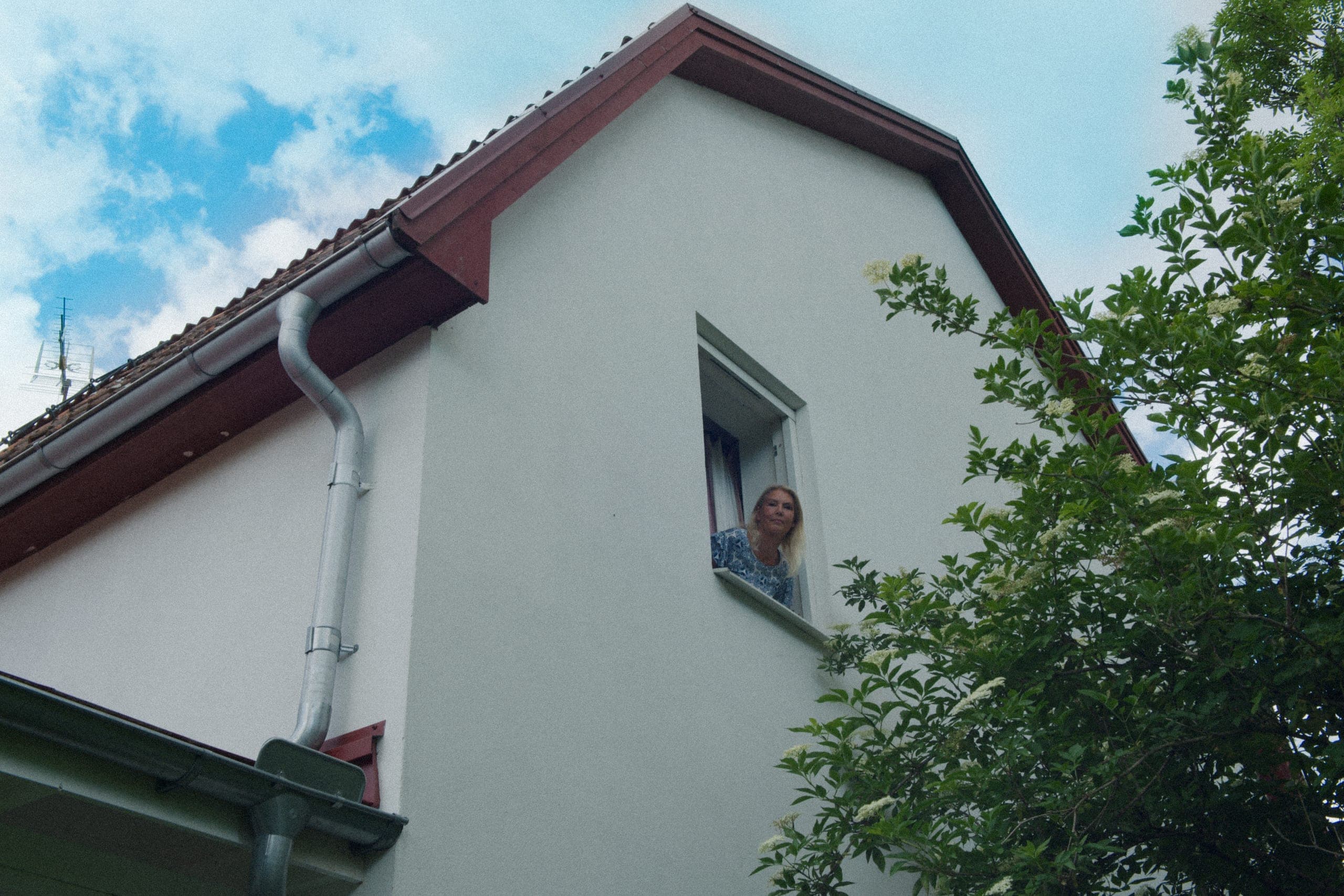 Elvy-kund som tittar ut genom fönstret i sitt hus
