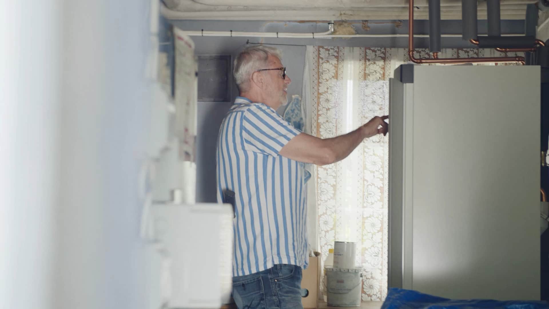 Elvy customer opening the heat pump hatch in the utility room