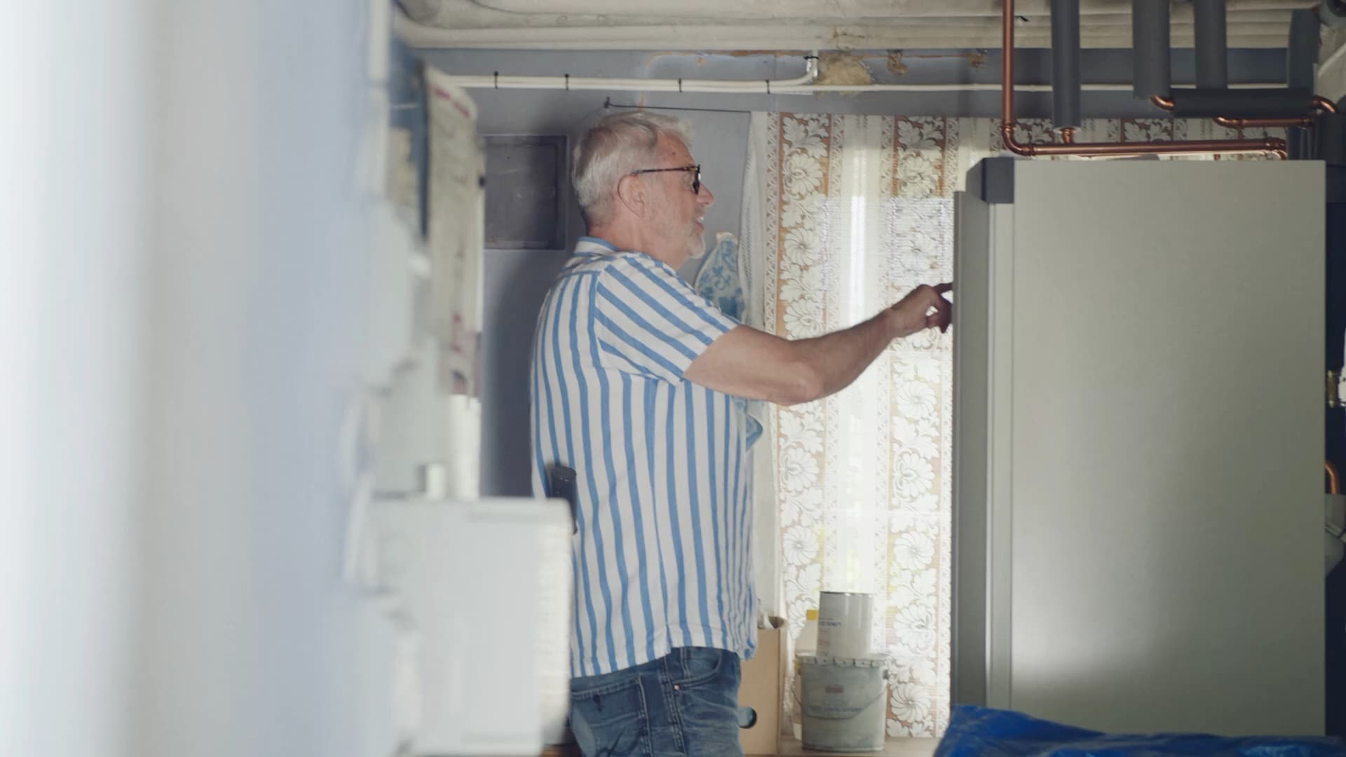 Elvy-kund öppnar luckan till värmepumpen i teknikrummet