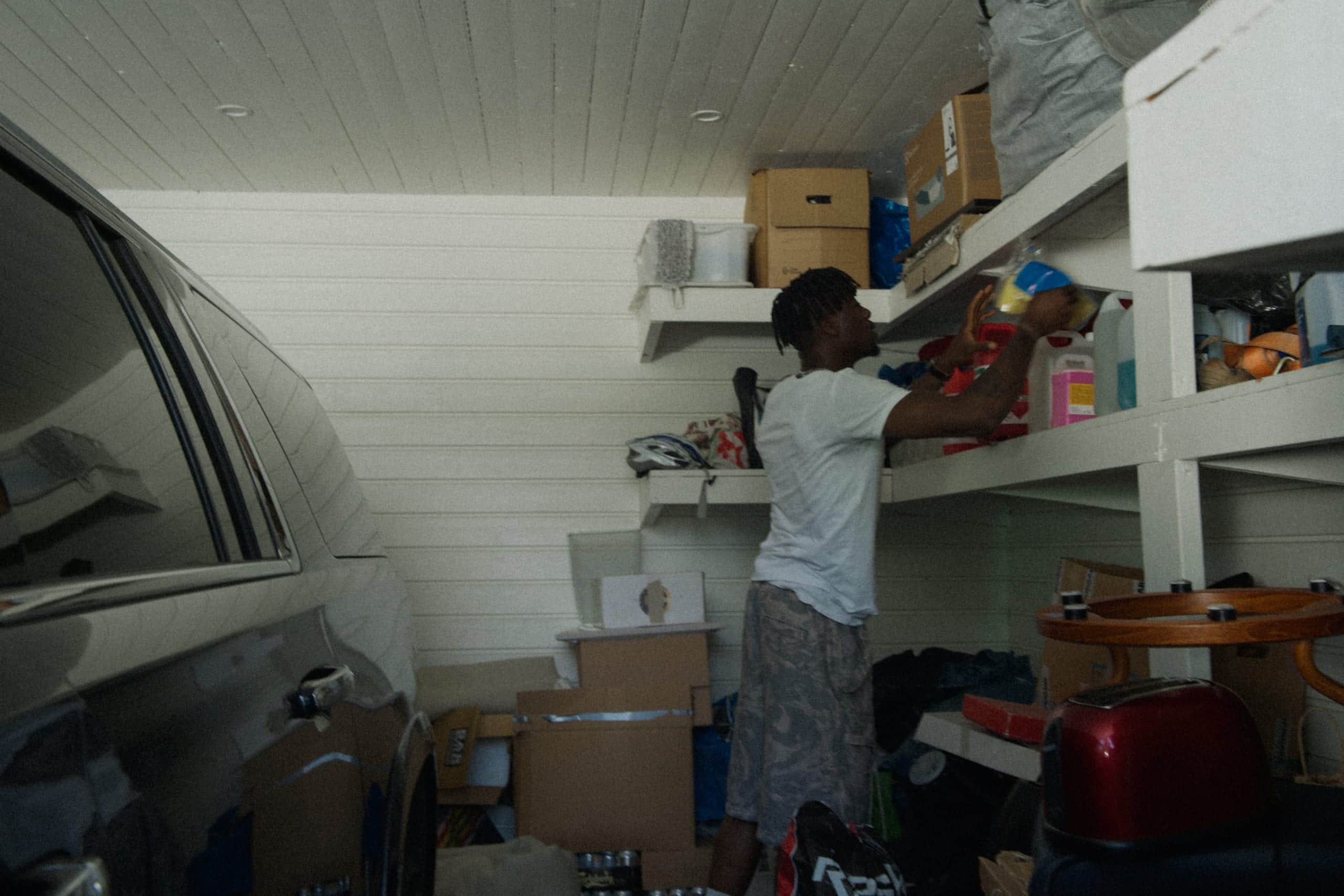 Elvy customer tinkering in their villa garage with full shelves